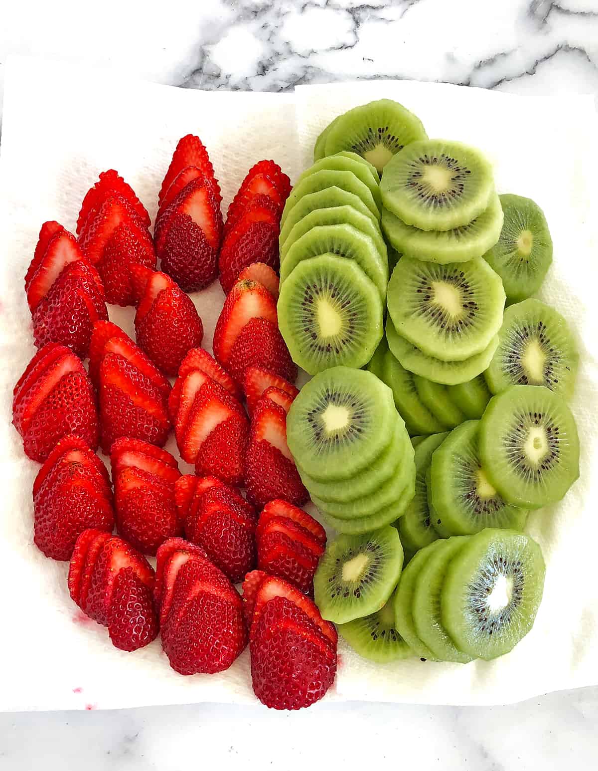Slice the kiwis and strawberries, place them onto a paper towel for the excess juice to be absorbed, and set them aside until they’re ready to be used.