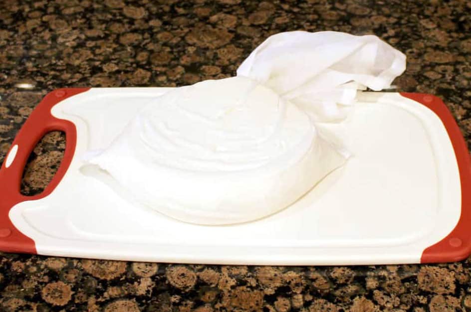 Place the cheese on a place and cover it with plastic wrap.