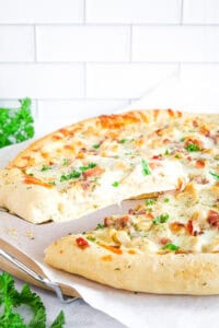 This Chicken Bacon Alfredo Pizza is a fresh oven-baked pizza loaded with extra Romano cheese, pressed garlic in Alfredo sauce