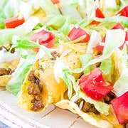 Crunchy chips with taco-flavored meat, spicy cheese, loaded with vegetables, sprinkled with extra shredded cheese, and topped off with a sour cream dressing is a tasty and easily loved meal!