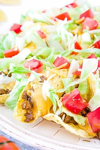 Crunchy chips with taco-flavored meat, spicy cheese, loaded with vegetables, sprinkled with extra shredded cheese, and topped off with a sour cream dressing is a tasty and easily loved meal!