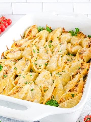 This Stuffed Shells recipe features that perfect stuffing! This delicious dish is made with soft pasta shells filled with a tasty mixture of ground beef, mushrooms, and a variety of cheeses, then baked to perfection in a rich roasted garlic pasta sauce.