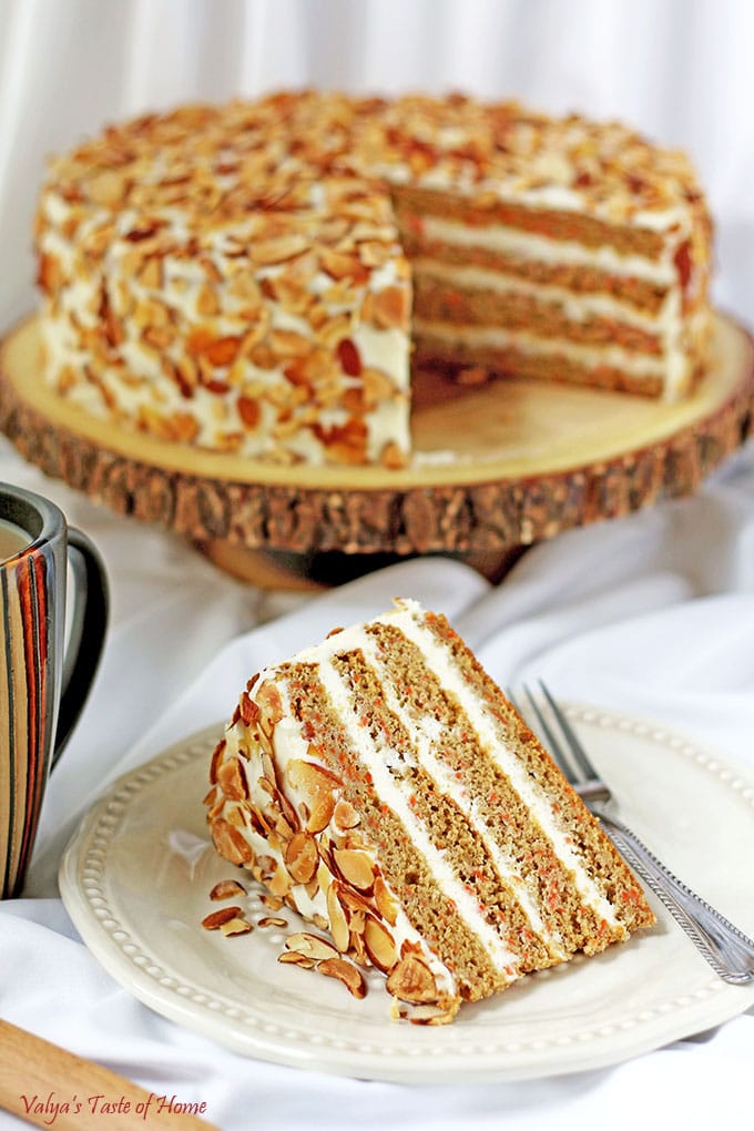 This Healthier Homemade Carrot Cake recipe is my very own made-up recipe; a baker's creation. The Greek yogurt adds that deliciously sour offsetting taste to the sweet buttercream frosting. Toasted almond chips finish that irresistible tasty slice of cake, which goes wonderfully with a cup of tea or coffee. #healthiercarrotcake #fallbaking #cleaneating #valyastasteofhome