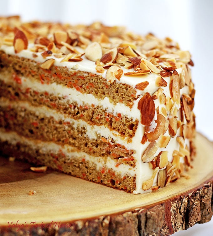 This Healthier Homemade Carrot Cake recipe is my very own made-up recipe; a baker's creation. The Greek yogurt adds that deliciously sour offsetting taste to the sweet buttercream frosting. Toasted almond chips finish that irresistible tasty slice of cake, which goes wonderfully with a cup of tea or coffee. #healthiercarrotcake #fallbaking #cleaneating #valyastasteofhome