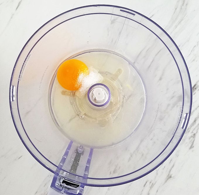 Start by adding egg (I used a cold egg instead of room temperature eggs), salt, freshly squeezed lemon juice, and garlic juice into the food processor bowl. 
