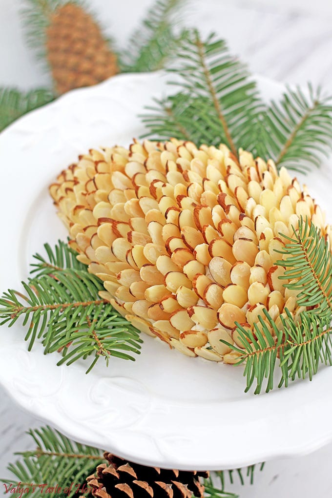 This particular pine cone cheese ball recipe features delicious smokiness from bacon, a tasty crunch from toasted almonds, and the creaminess and richness of cream cheese. 