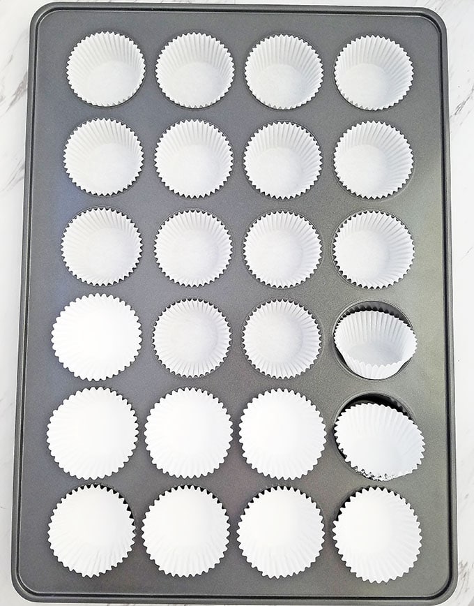 Start by lining a cupcake baking pan with cupcake liners.