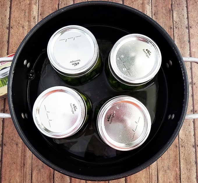 Ensure the lid of each jar is screwed on tightly, then turn the stove on high heat until the water starts boiling.