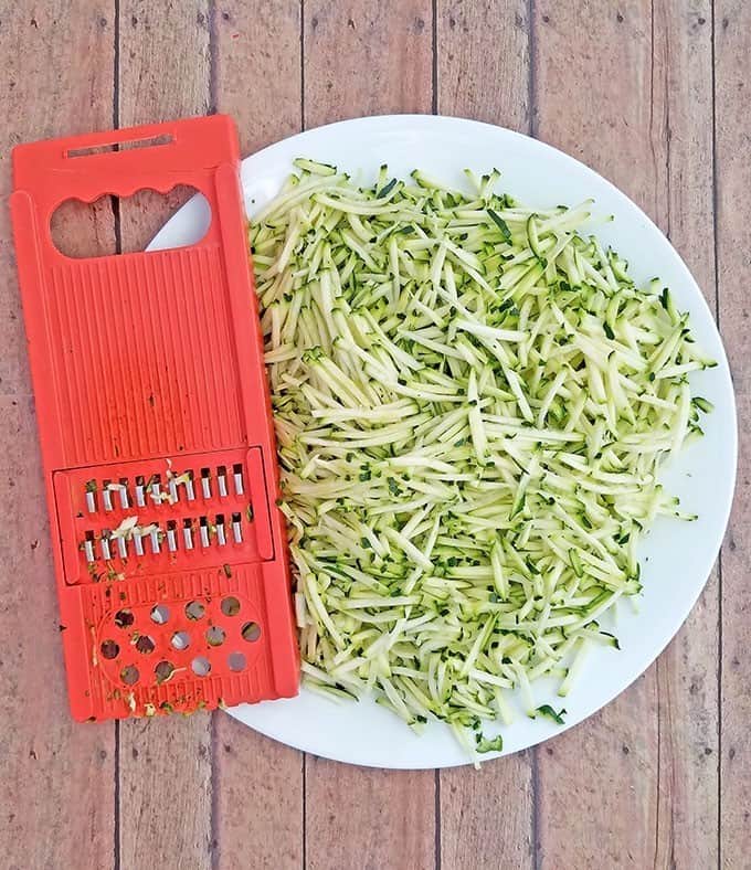 Grate zucchinis and set aside. Combine all dry ingredients. Line muffin pan with paper liners.