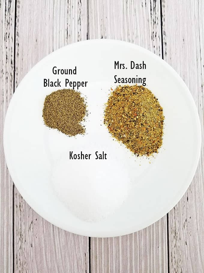 Measure the spices and mix them together in a small bowl: a tablespoon of Mrs. Dash seasoning, two tablespoons of salt, and a teaspoon of freshly ground black pepper.