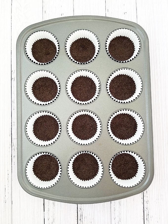 Fill each liner with 1 ½ tbsp. of Oreo crumbs, then press the crumbs down firmly using the back of the measuring spoon. 
