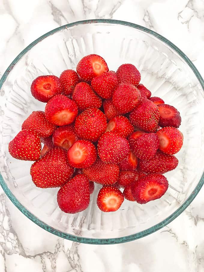 Start by rinsing and removing the stems of your strawberries.