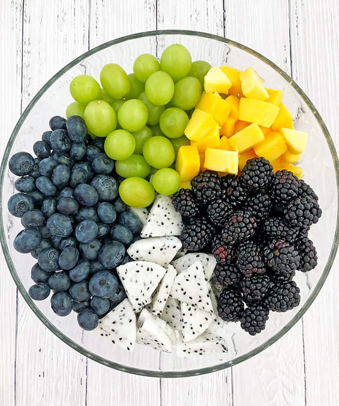 Start by rinsing the fruits and patting them dry with a paper towel. Next, peel, dice, or slice all the fruits, and place them into a large bowl.