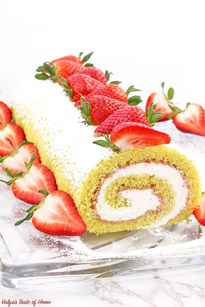 This Strawberry Vanilla Swiss Roll Recipe is the easiest and the quickest dessert you can ever make! Supper soft sponge cake topped with amazingly tasty (no cook) strawberry sauce, filled with super soft and fluffy cream, dusted with confectioners’ sugar and topped with loads of fresh strawberries. 