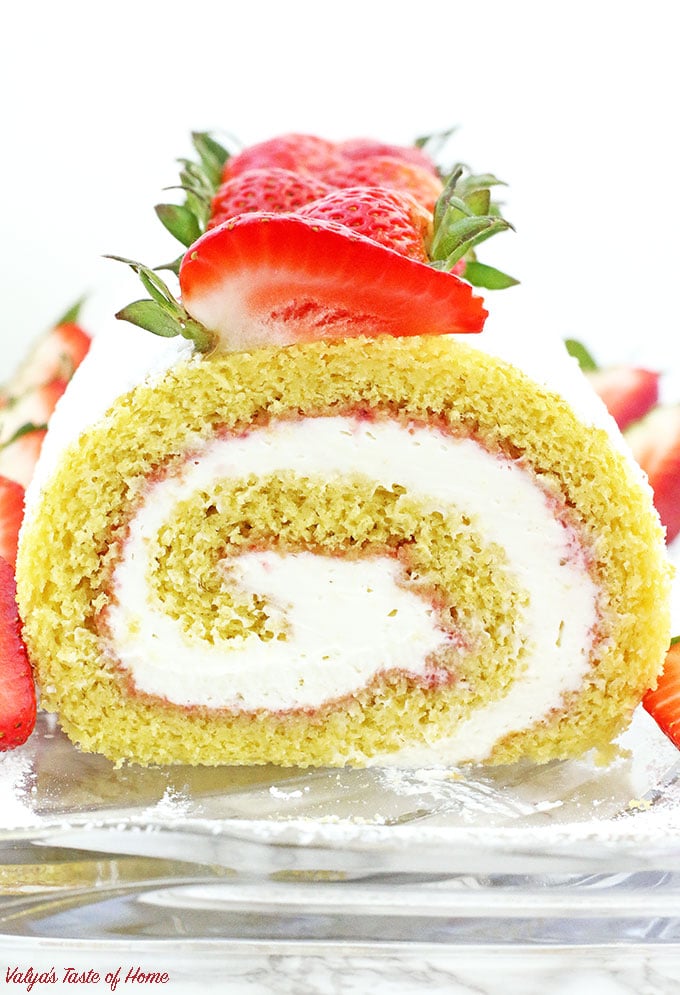 This Strawberry Vanilla Swiss Roll Recipe is the easiest and the quickest dessert you can ever make! Supper soft sponge cake topped with amazingly tasty (no cook) strawberry sauce, filled with super soft and fluffy cream, dusted with confectioners’ sugar and topped with loads of fresh strawberries. 