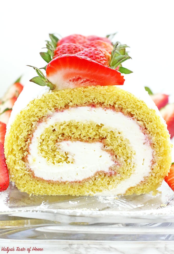 This Strawberry Vanilla Swiss Roll Recipe is the easiest and the quickest dessert you can ever make! Supper soft sponge cake topped with amazingly tasty (no cook) strawberry sauce, filled with super soft and fluffy cream, dusted with confectioners’ sugar and topped with loads of fresh strawberries.