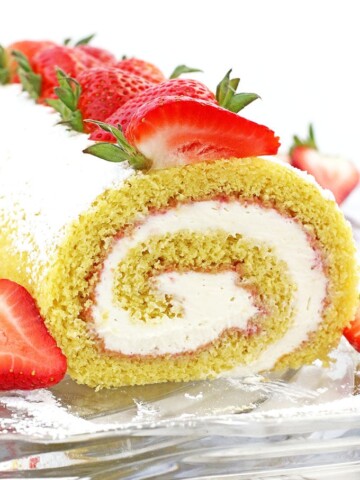 This Strawberry Vanilla Swiss Roll Recipe is the easiest and the quickest dessert you can ever make! Supper soft sponge cake topped with amazingly tasty (no cook) strawberry sauce, filled with super soft and fluffy cream, dusted with confectioners’ sugar and topped with loads of fresh strawberries.