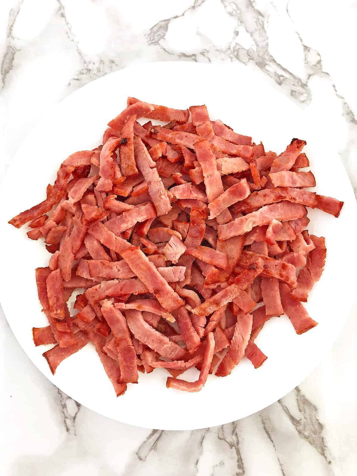 Cut bacon into strips and sauté it for a couple of minutes by using the same pan as for the eggs and ham.