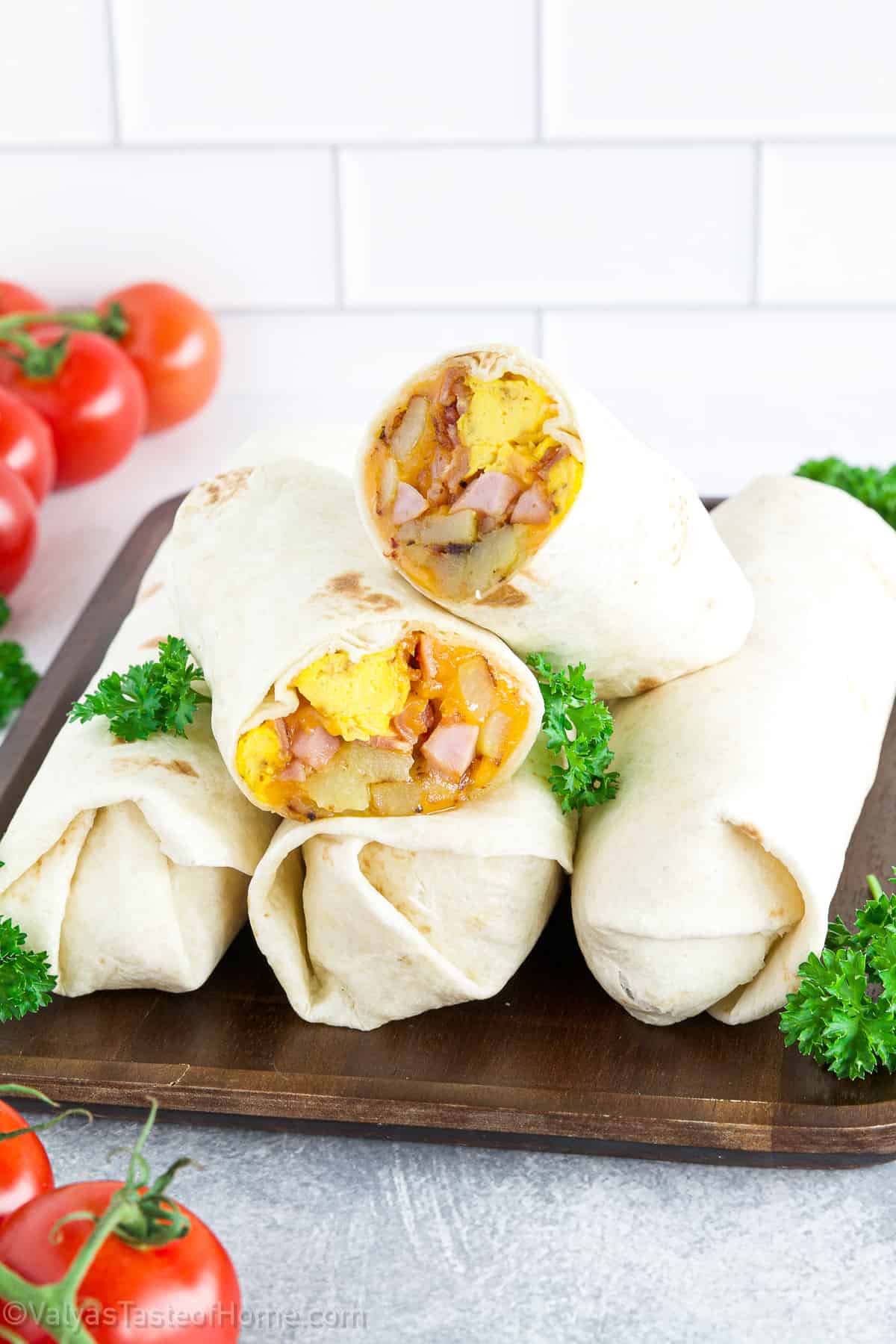 In this dish, fluffy scrambled eggs, crispy bacon, savory ham, soft potatoes, and sharp cheddar cheese are all wrapped in a warm flour or wheat tortilla. 