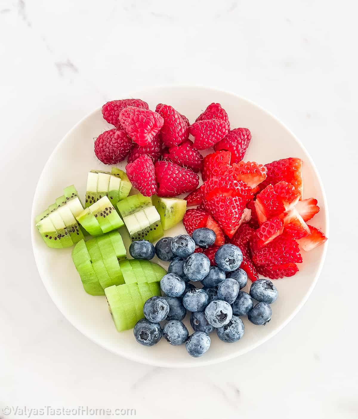 Start by rinsing the fruits under cold water. Pat them dry with a paper towel. Slice the strawberries and kiwi into bite-sized pieces.