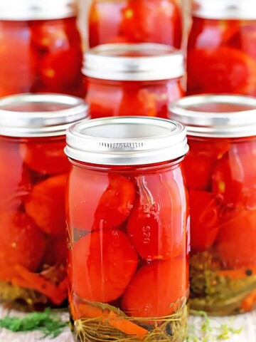 I grew up canning fruits and vegetables with my mom and still enjoy doing it to this day. I’ve tried a few different blends in the past. This particular Canned Tomatoes Recipe is my aunt Lyuda’s, and the one that takes the number one spot for me.