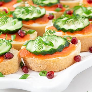 Smoked Salmon Canapes are exactly what they sound like: delicious bite-sized savory appetizers that are topped with smoked salmon, cream cheese, dill, and other toppings to take it to the next level.