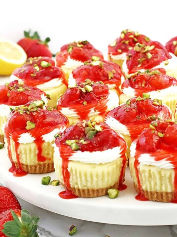These Mini Strawberry Cheesecakes are made of a buttery graham cracker crust, the tastiest creamy cheesecake filling, and delicious chunky strawberry sauce.