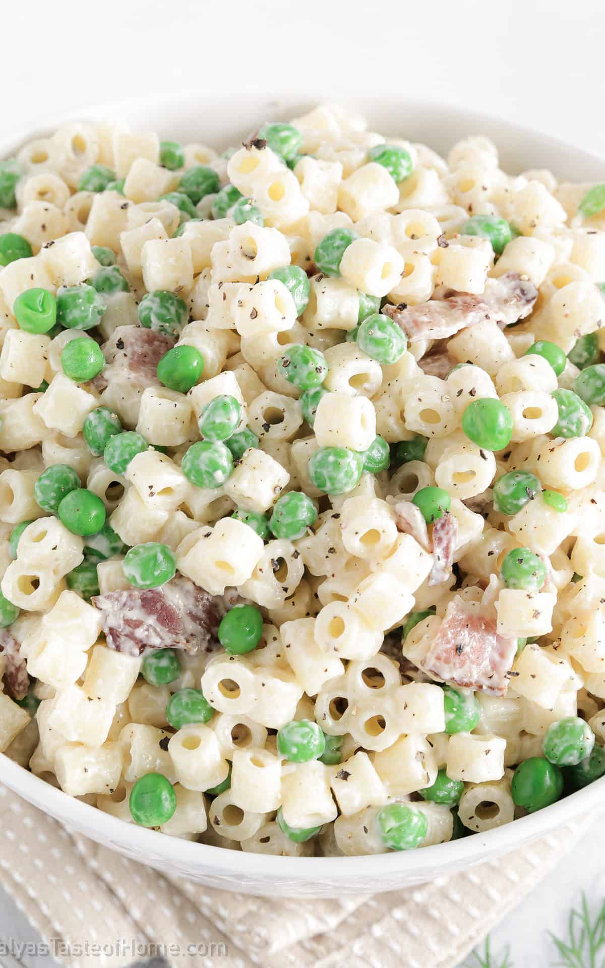 This classic Italian-inspired meal combines the smoky flavor of bacon with the sweetness of peas, all tossed together in a creamy sauce.