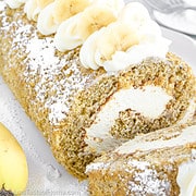 This Banana Roll recipe features a fluffy and moist banana sponge cake filled with creamy and rich cream cheese frosting. It's then rolled up into a spiral shape and dusted with powdered sugar.