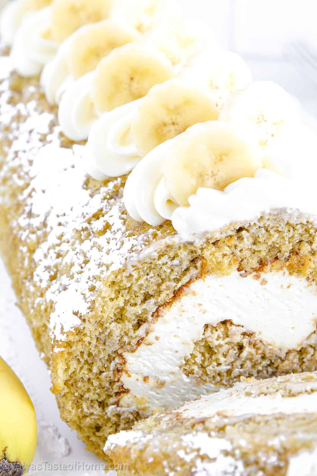 This Banana Roll features a fluffy and moist banana sponge cake filled with rich cream cheese frosting which is then rolled up and dusted with powdered sugar.