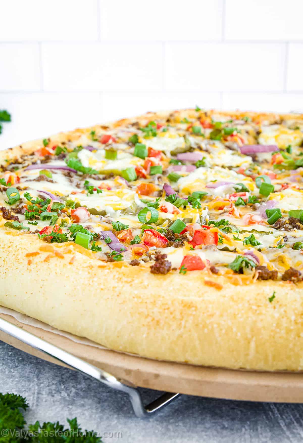 Cheeseburger pizza is inspired by the classic cheeseburger. It typically consists of a pizza crust topped with ground beef, cheddar cheese, tomatoes, onions, pickles, and with a ketchup sauce base.