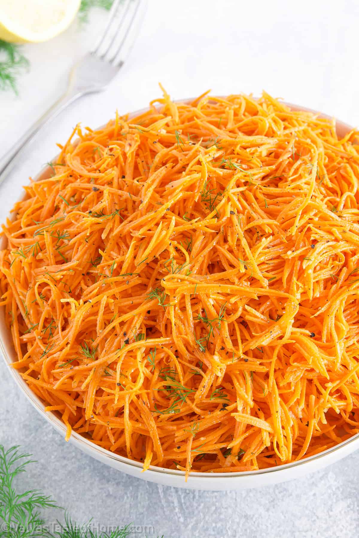 This salad is a delightful mix of fresh ingredients such as julienne carrots, garlic cloves, spices, and lemon juice or rice vinegar tossed together in a large bowl. 