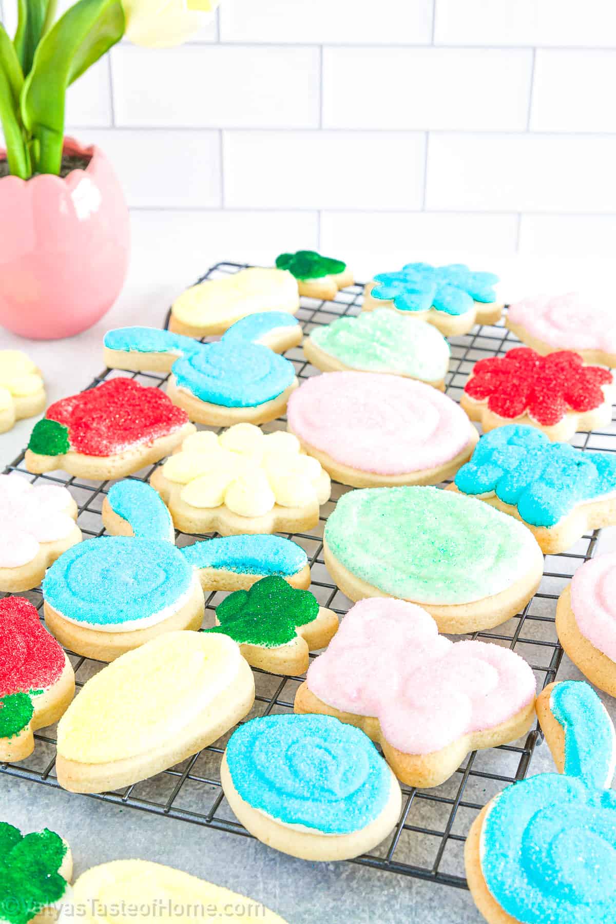 The recipe involves a simple sugar cookie dough, cut into shapes using a cookie cutter, baked to perfection, and then topped with a generous layer of sweet, creamy frosting. 