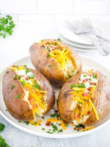 Slice open the potatoes, fluff the inside with a fork, and add your favorite toppings like butter, sour cream, cheese, bacon bits, or chives.