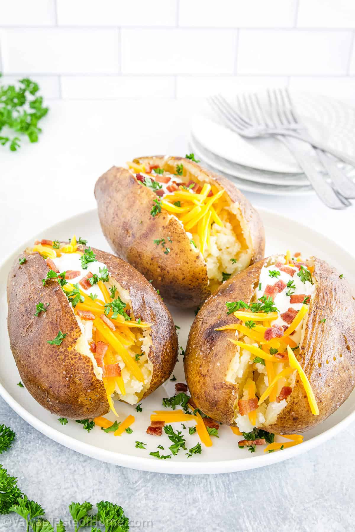 Slice open the potatoes, fluff the inside with a fork, and add your favorite toppings like butter, sour cream, cheese, bacon bits, or chives.